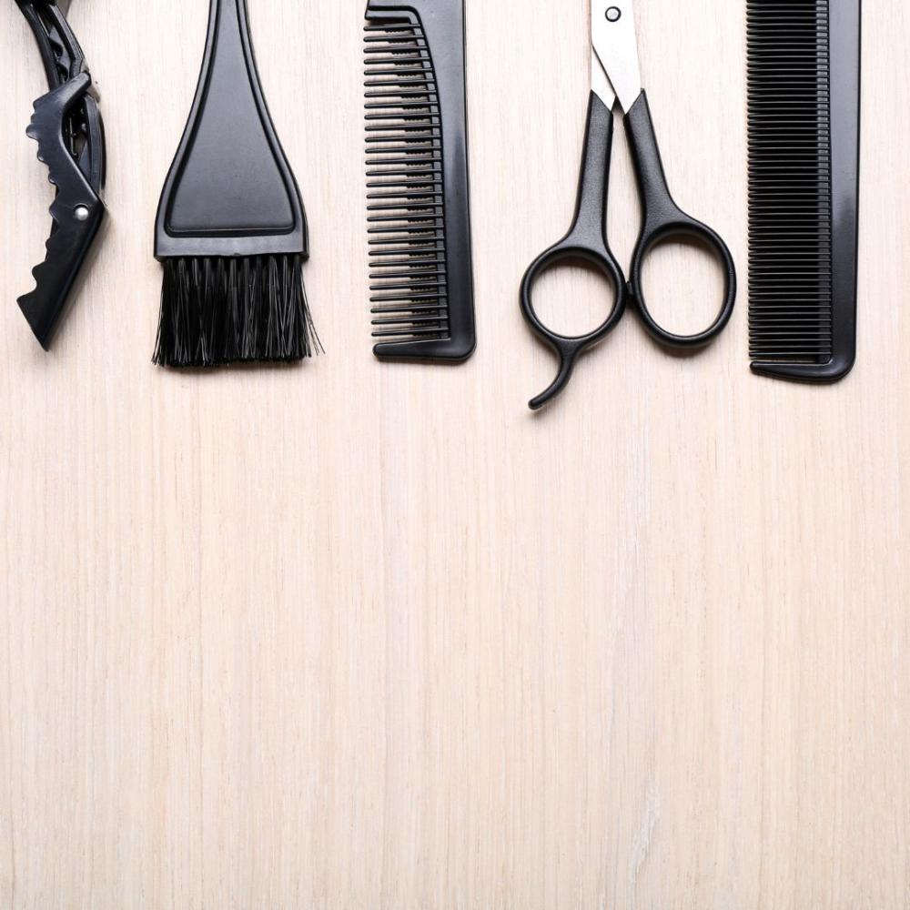 A wooden background with hair stylists products lined at the top of the image