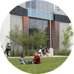 Students sitting on the lawn outside campus