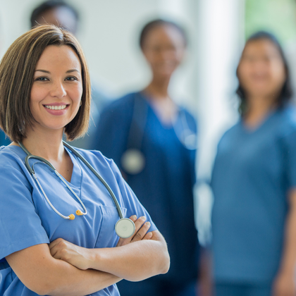 An image of nurses standing and smiling