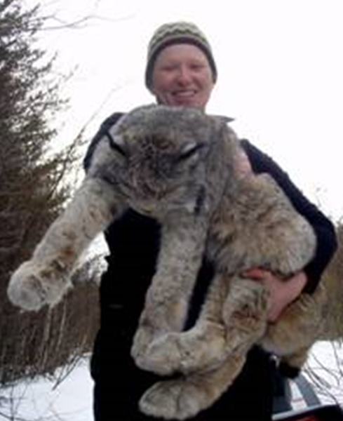 student, Meagan, wearing toque, holding a large lynx in her arms!