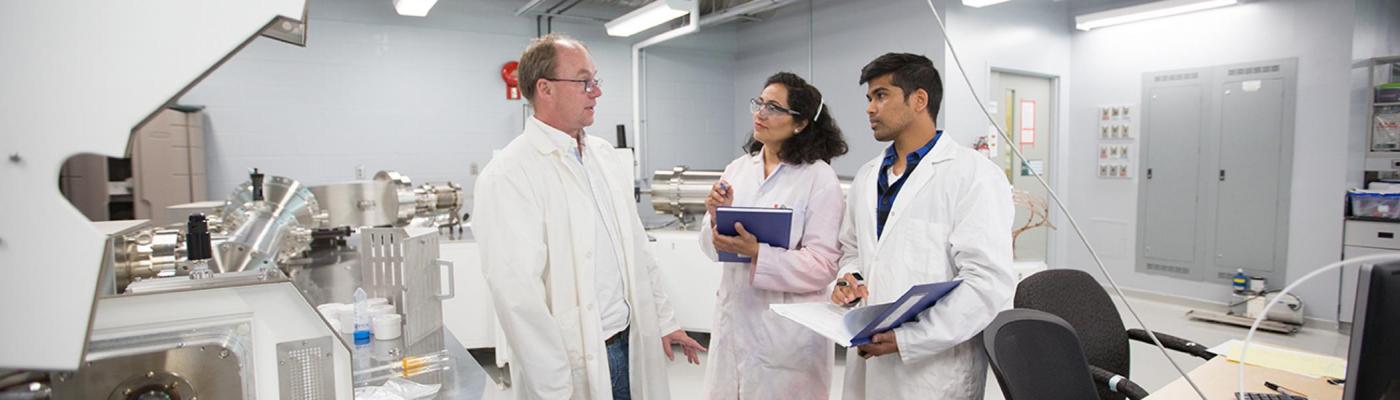 Students speaking with a professor in a Chemistry lab. 