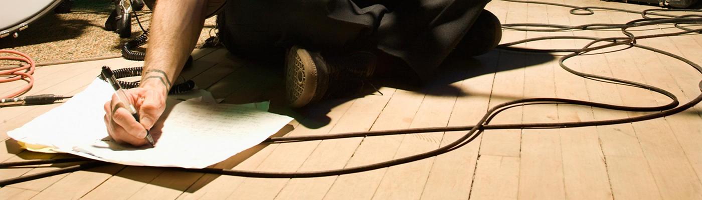 Hand writing on a piece of paper on the floor