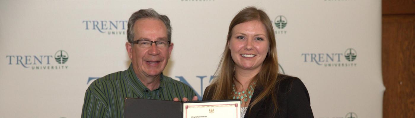 Jeff Leal and Lesley Hewitt standing beside each other holding an award