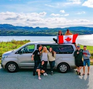 students in front of car