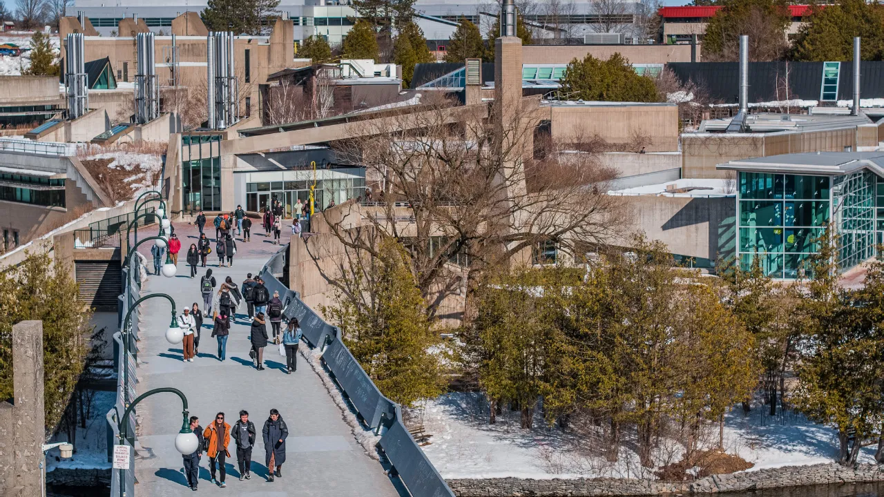 Aerial of students on the bridge in the winter.