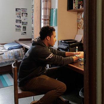 Student studying in Trent University residence room.