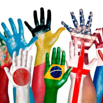Hands painted with flags of the world reaching up.