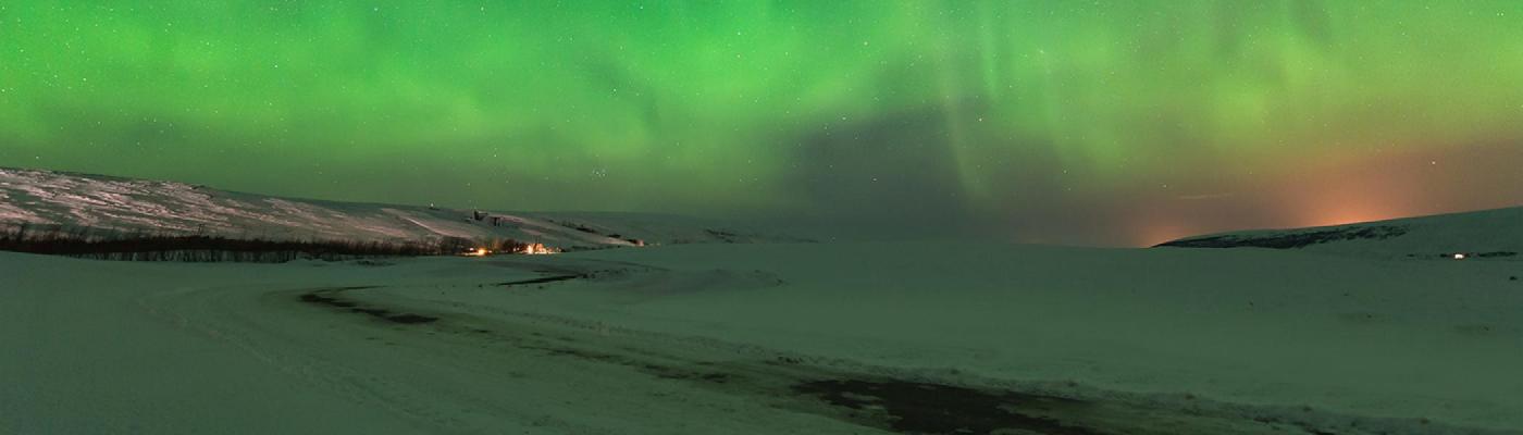 Aurora Boarealis at night over a tundra vista