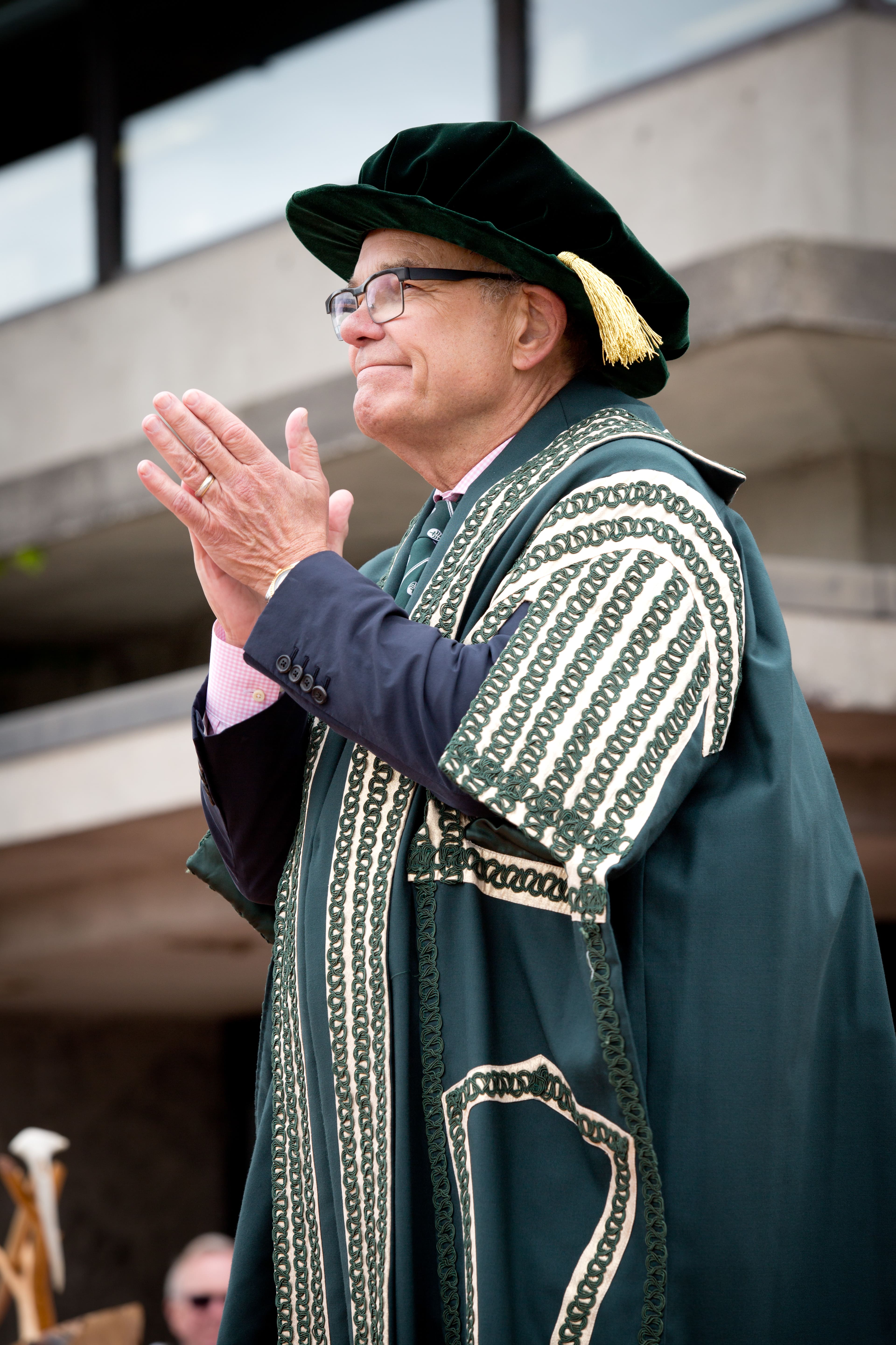 Chancellor Don Tapscott applauding at convocation.