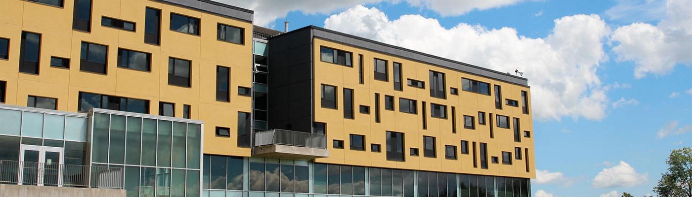 Looking up at the Gzowski building with a blue sky in the background.