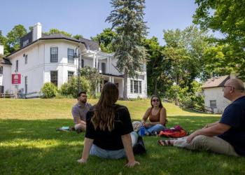 Students sitting on the grass at Traill