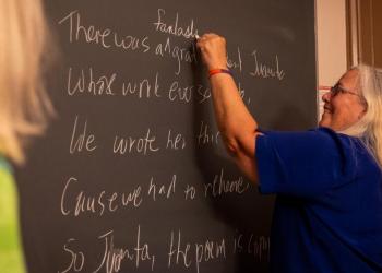 A professor writing on a blackboard