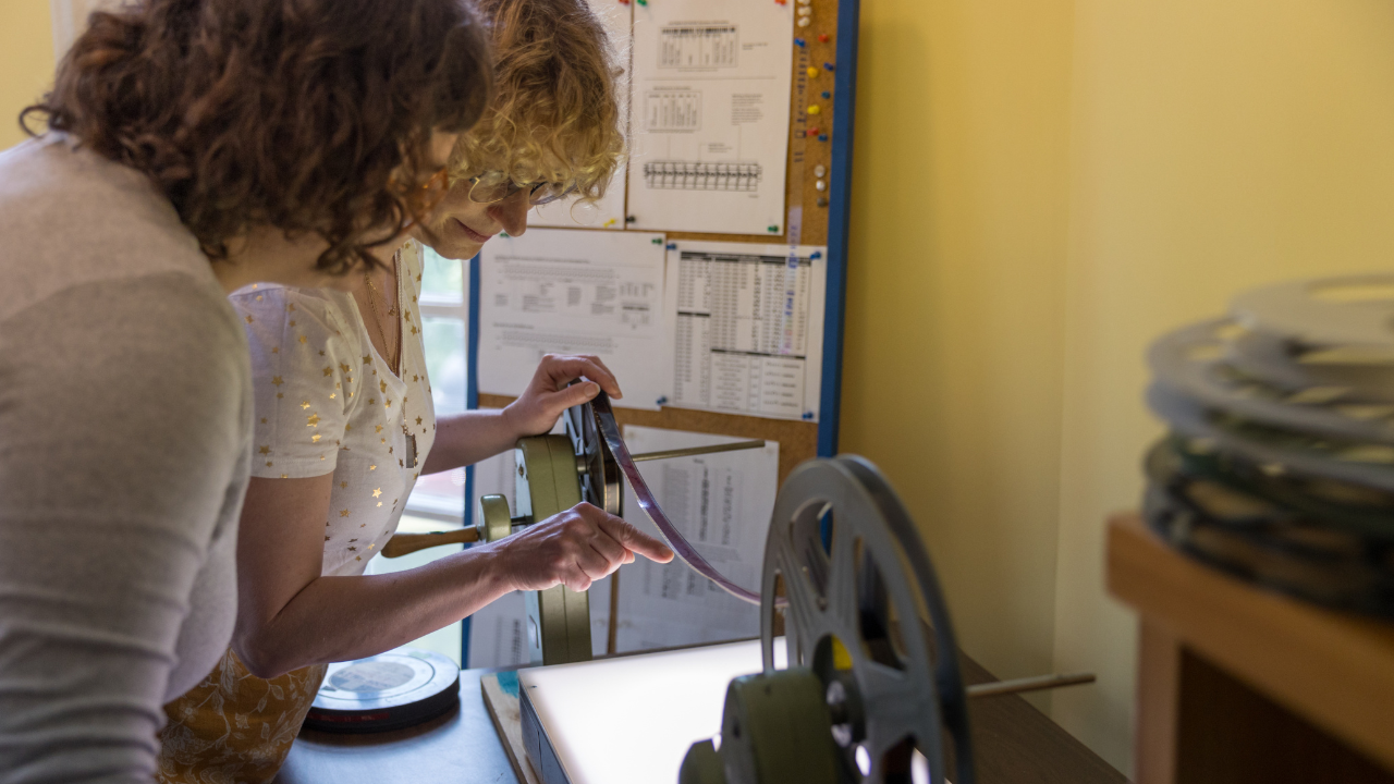 student and professor looking at film