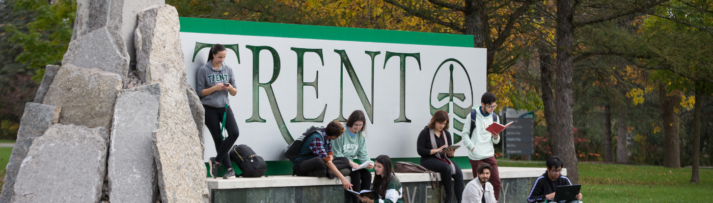 students hanging out by sign