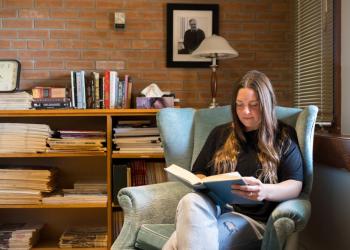 Student reading book at Traill