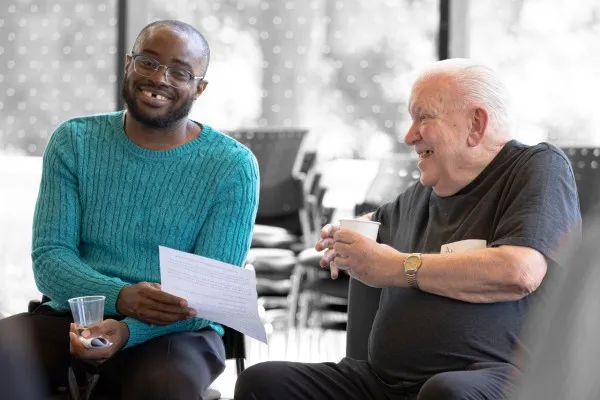 Young man and older man smiling together