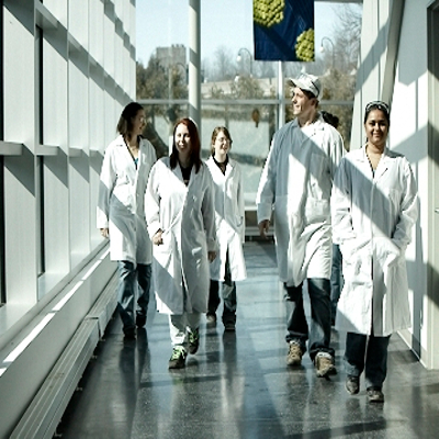 Students in lab coats walking down the halls of the Chemical Building
