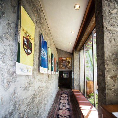 The interior hallway of Alumni house with banners hung along the wall that display the college's emblem and other Trent symbols