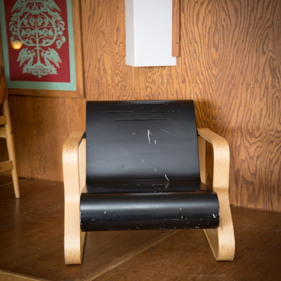Black plastic chair with wide and flat curved armrests and legs