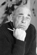 Alvar Aalto in black in white holding a pencil posing for a portrait