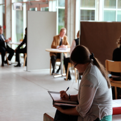 Interior of Gzowski college study area, filled with students at various tables and benches