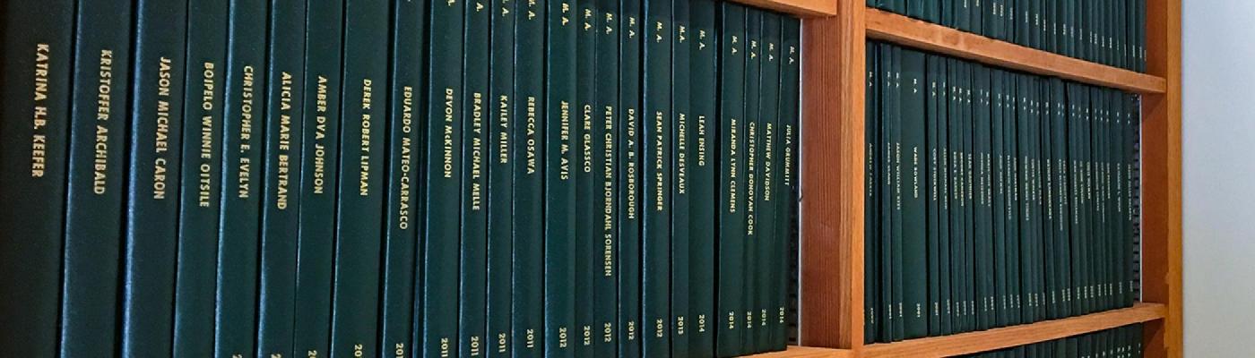 A stack of green history books on a wooden bookshelf