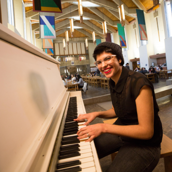 Student playing the piano in the Champlain College Great Hall 