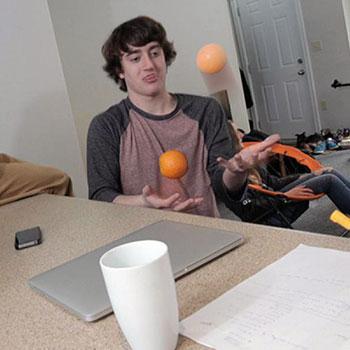Student in residence room, juggling oranges
