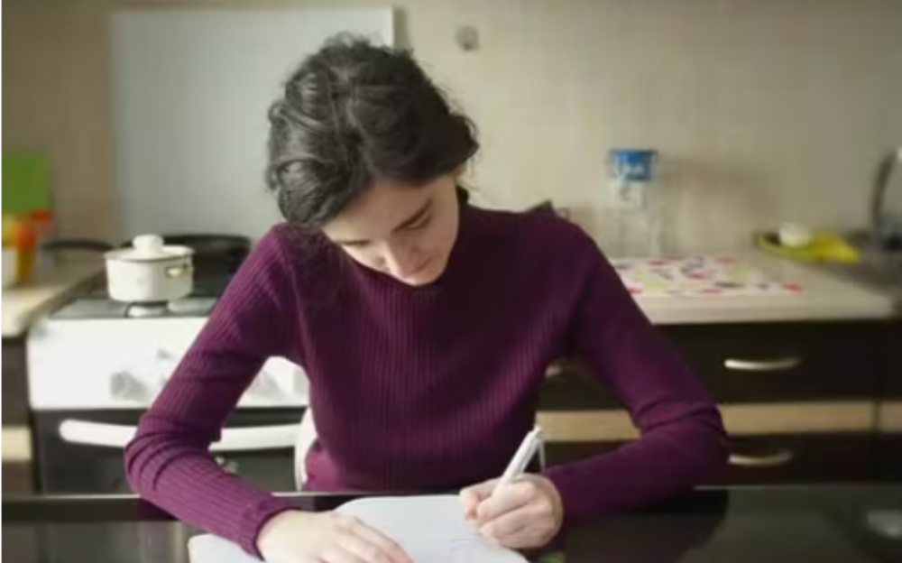 Student writing  in a library