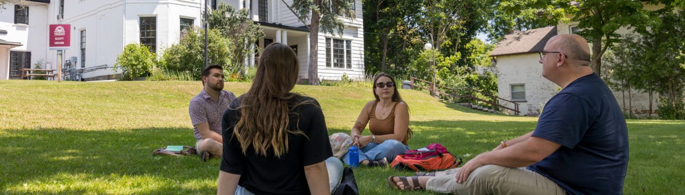 Students sitting on Traill College's front yard.