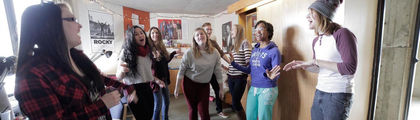 Students singing and dancing in residence room