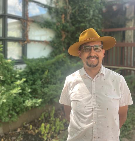 Faculty member standing in a garden