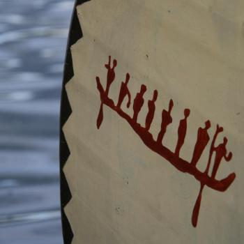 tribal art of 8 individuals on a canoe painted on front of canoe