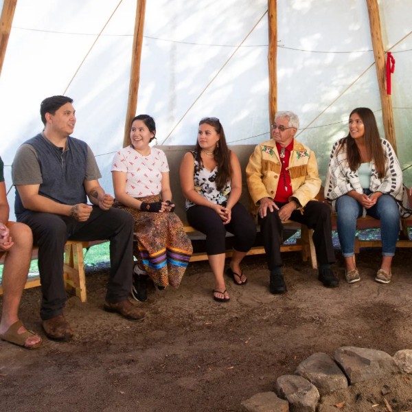 People talking inside a tipi