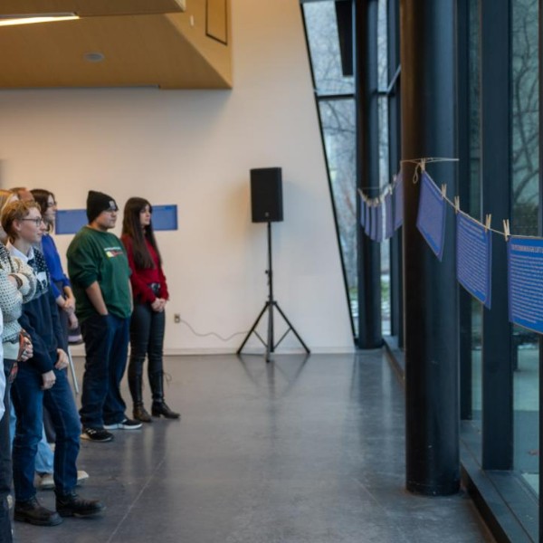 Students reading plaques made in a course