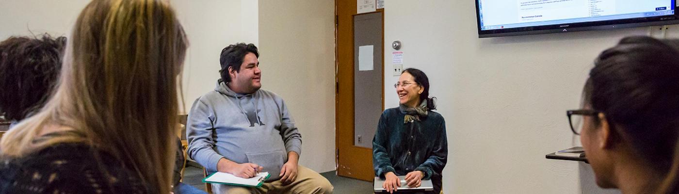 Lynne Davis sitting in a small group, teaching