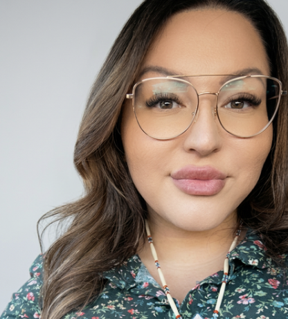 Woman with glasses and full lips looking directly at camera.