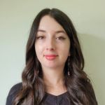 Woman with wavy, long brown hair and black eyeliner.
