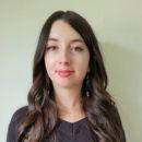 Woman with long brown wavy hair and black eyeliner
