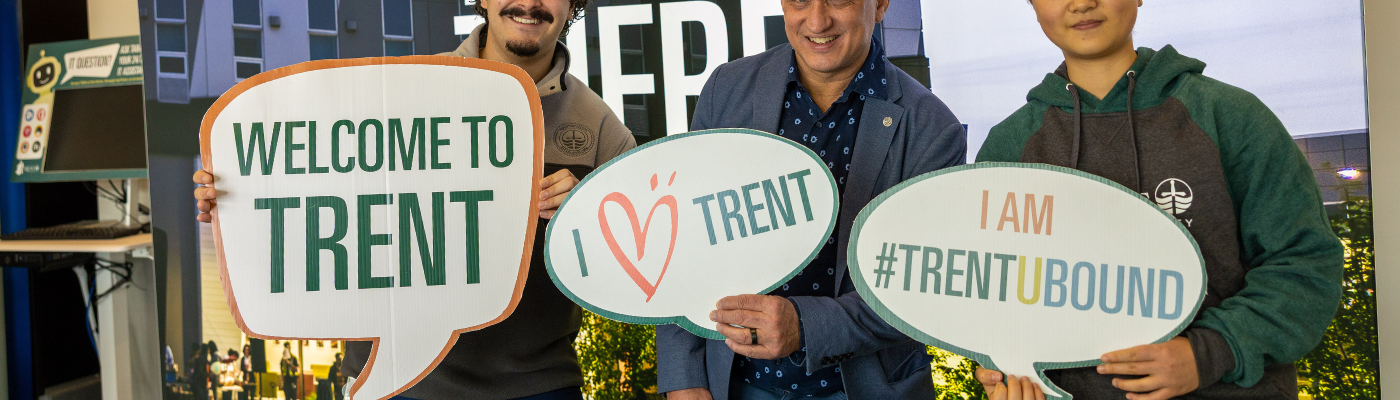 Three people standing and holding signs