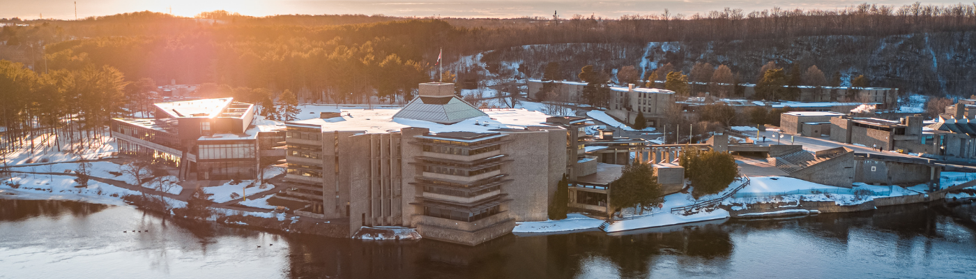 Aerial photo of Trent Peterborough campus in the winter, with a river running in front of the library