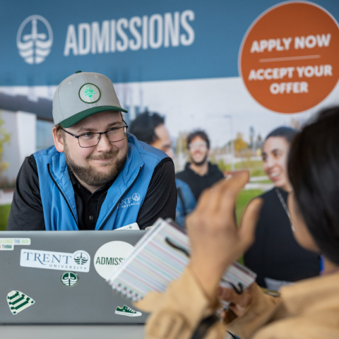 Trent Admissions staff helping a student apply at a desk