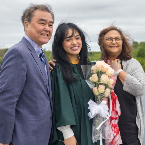 A student celebrating her graduation with their parents