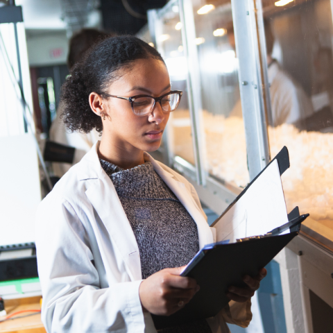 Student reading her notes in a lab