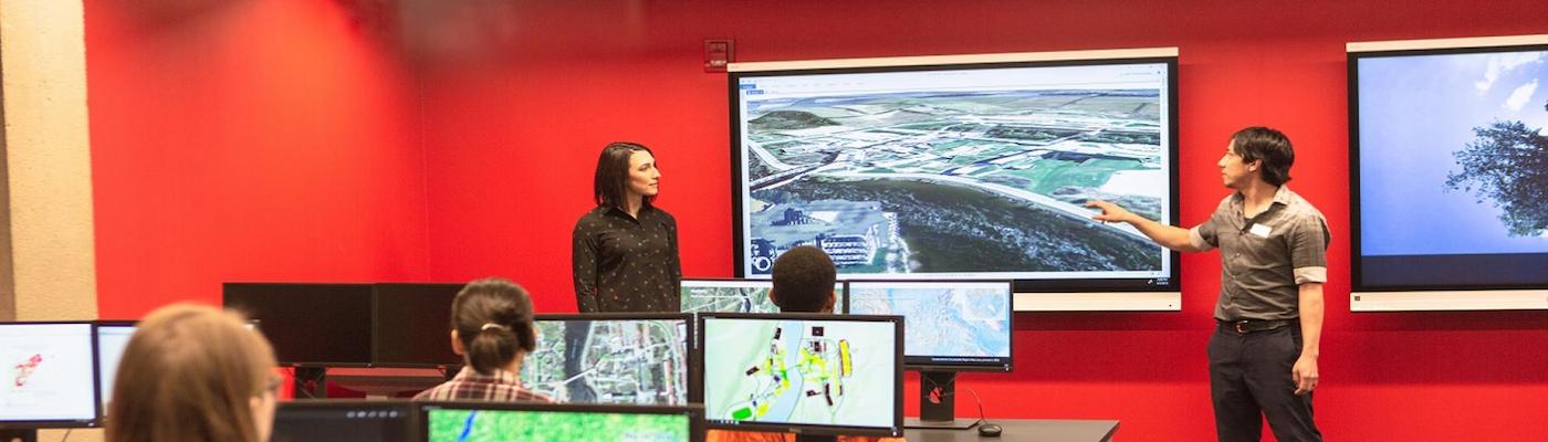 GIS class taking place with students at computers, instructors at the front