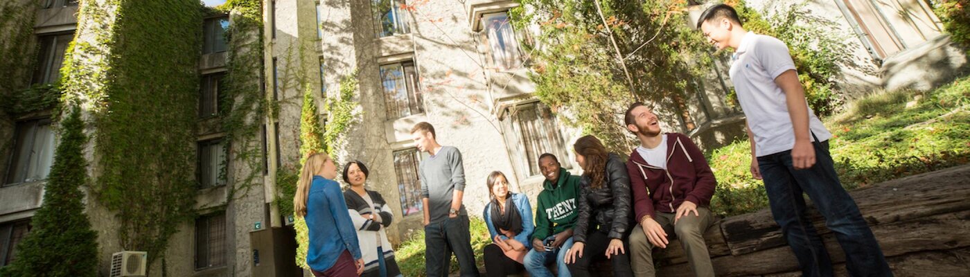 Student chatting with on another in Champlain garden in a fall day 