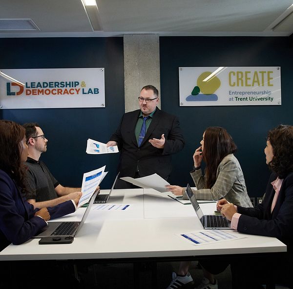 A man presents to a board room of business students