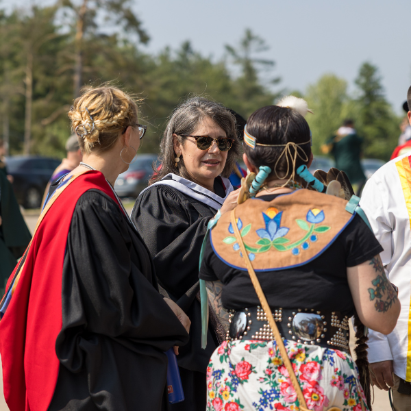 Julie at convocation speaking to students outside