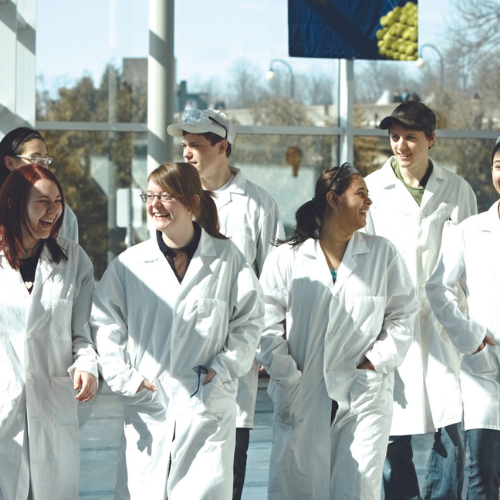 Students walking in lab coats