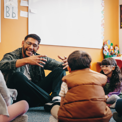A teacher speaks to young children in a circle